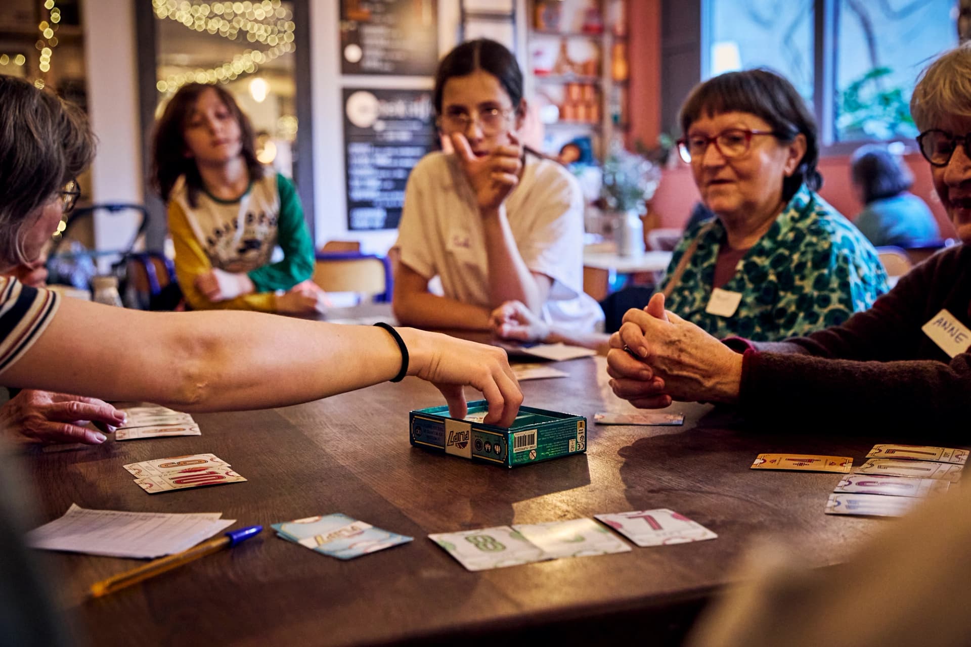 Participant·es jouant aux cartes autour d’une table