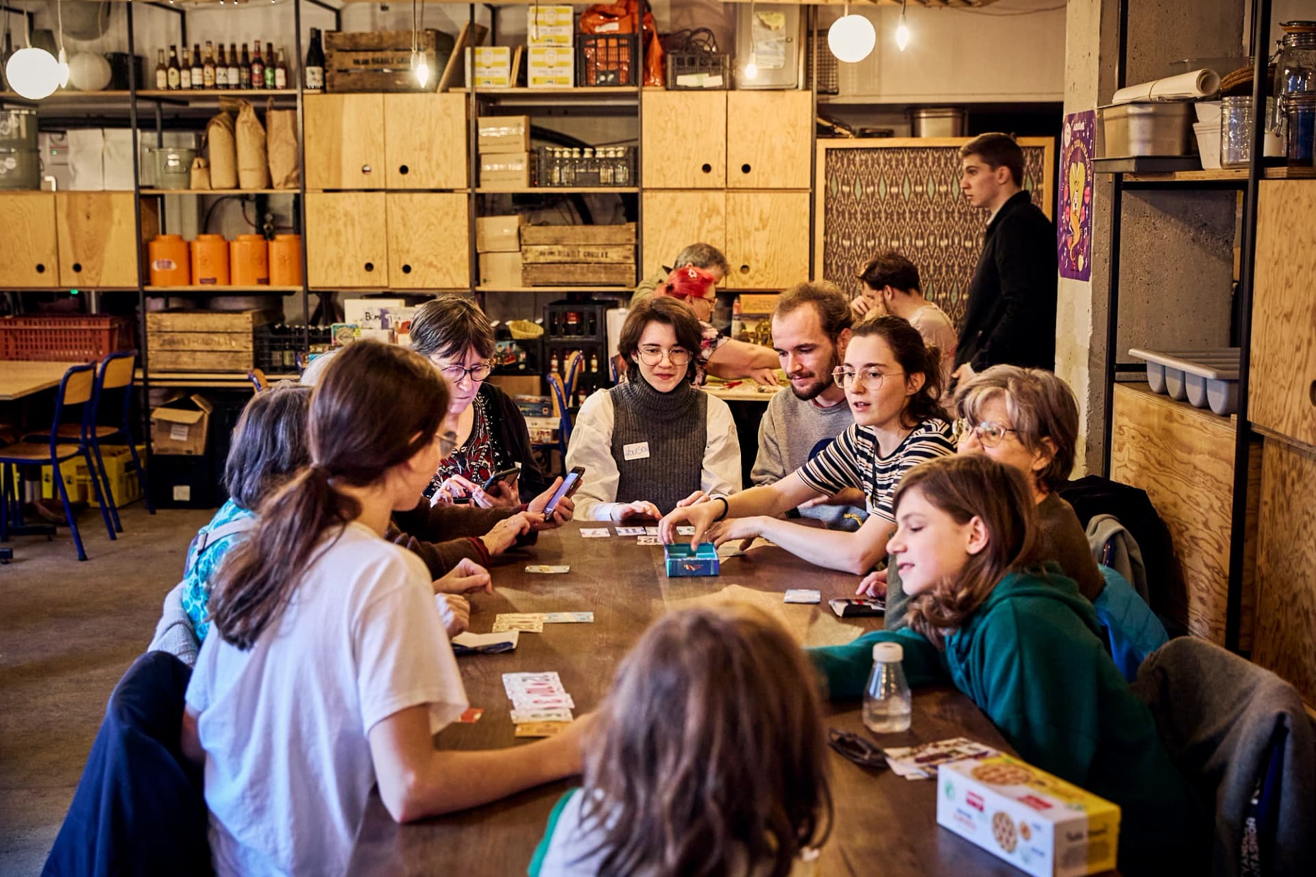 Grand groupe de joueur·euses autour d’une table dans un lieu partenaire