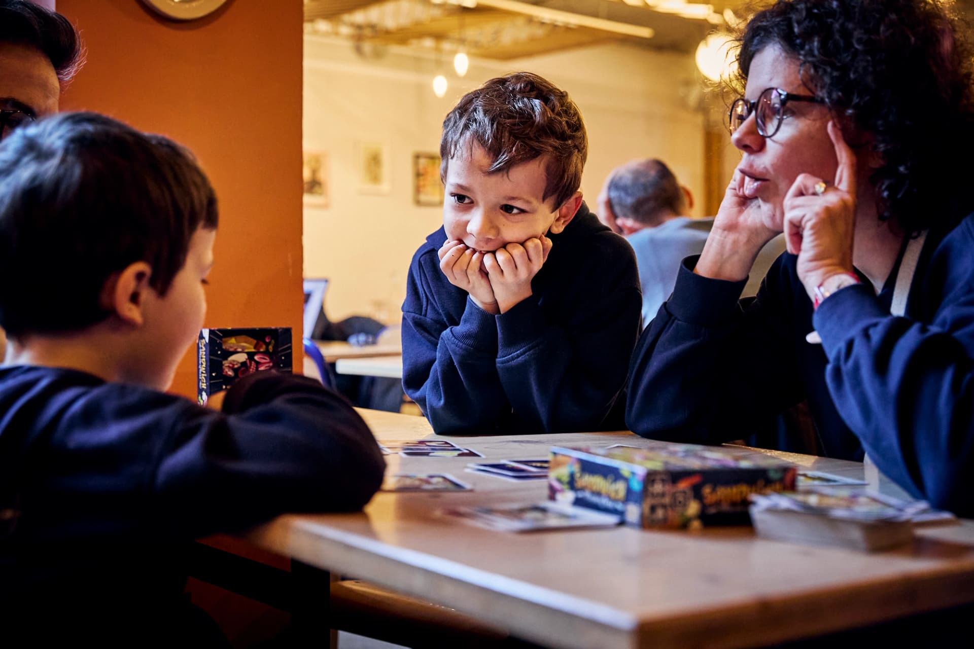 Enfant observant une partie de jeu de société avec attention