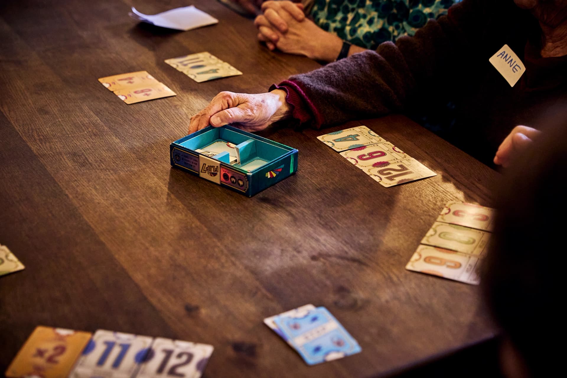 Main posant une pièce sur un plateau de jeu de société