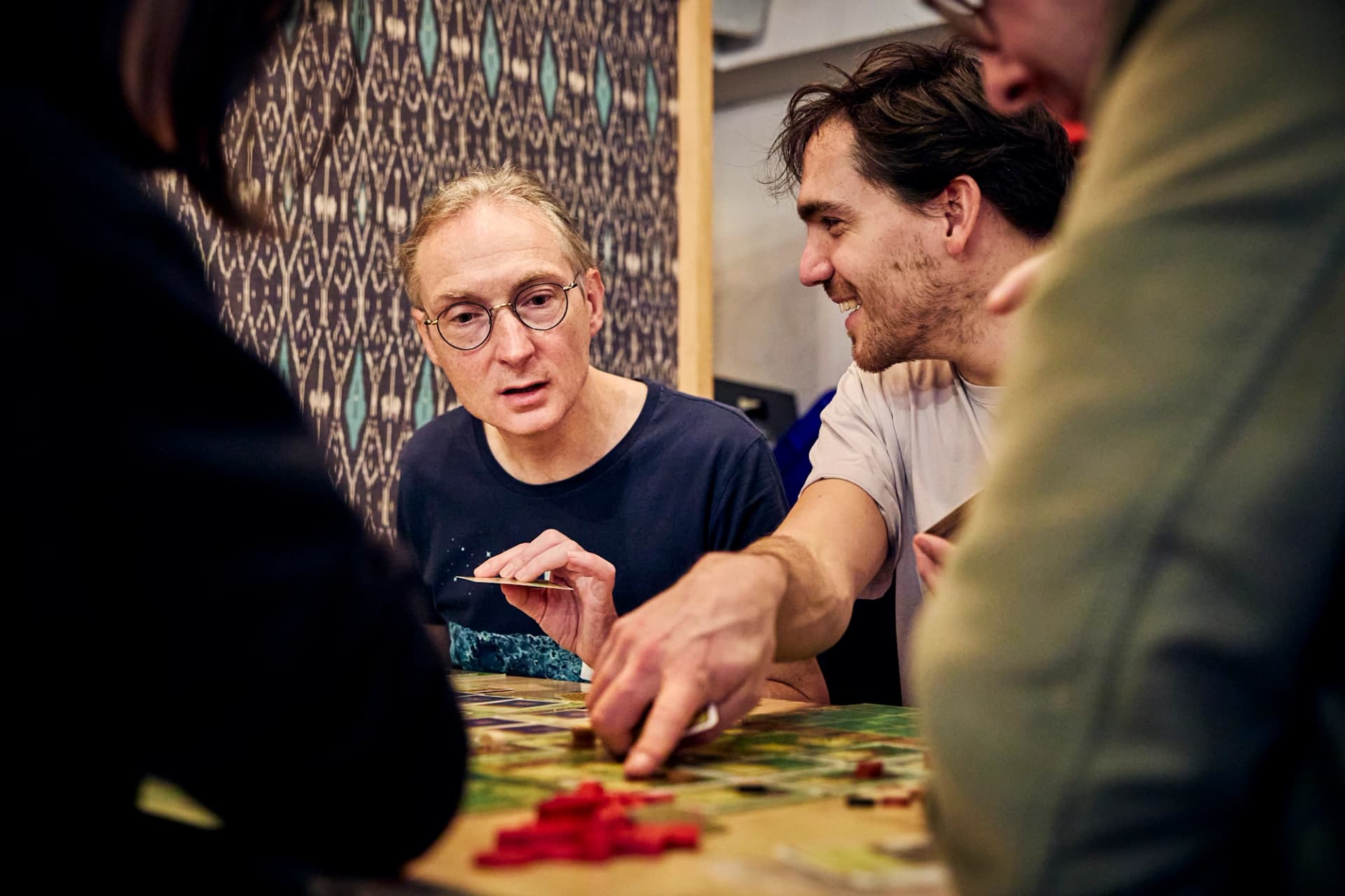 Deux participant·es souriant autour d’un plateau de jeu