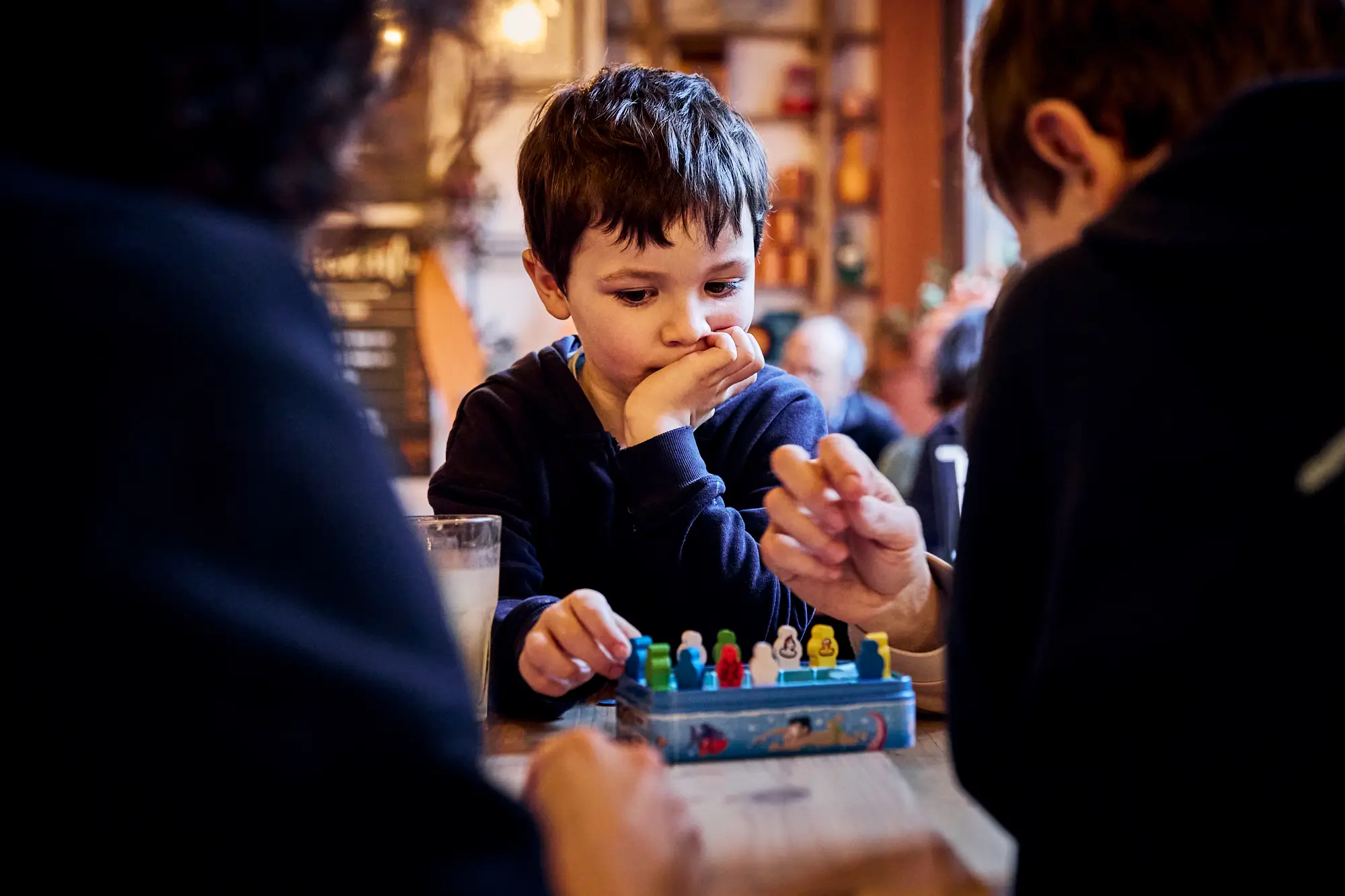 Enfant concentré devant des pions colorés